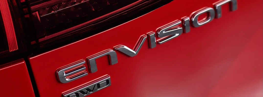 A closeup of the badging on the rear of a red 2026 Buick Envision.